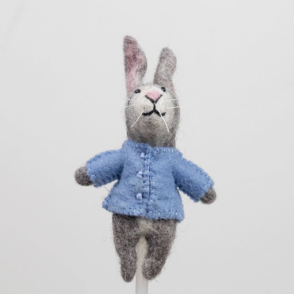Handcrafted rabbits finger puppet made from natural wool, featuring outfits against a white backdrop