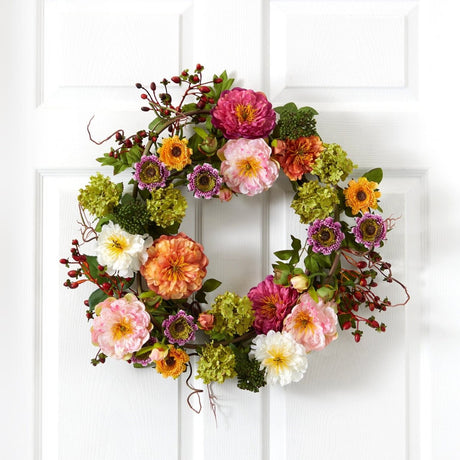 Colorful artificial peony floral wreath on a white door
