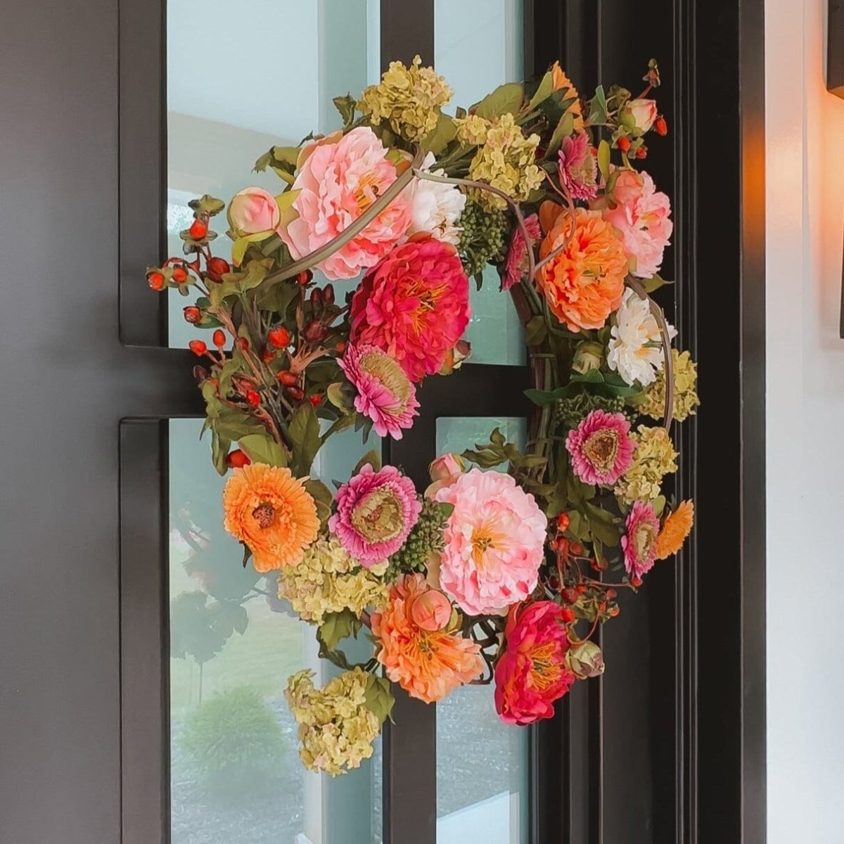 Colorful artificial peony floral wreath on a door