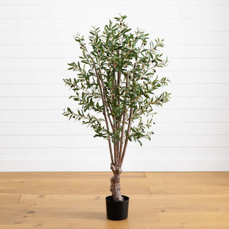 Potted artificial olive tree on a wooden floor with a white wall background