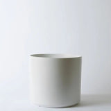 White ceramic planter on a light gray background