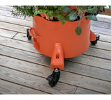 Orange rolling plant pot with plants on a wooden deck