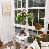 Cozy corner with a small table, chair, and decorative items in a sunroom.