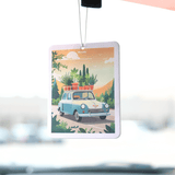 Car air freshener with a scenic design of a car and plants hanging from a car's rearview mirror.